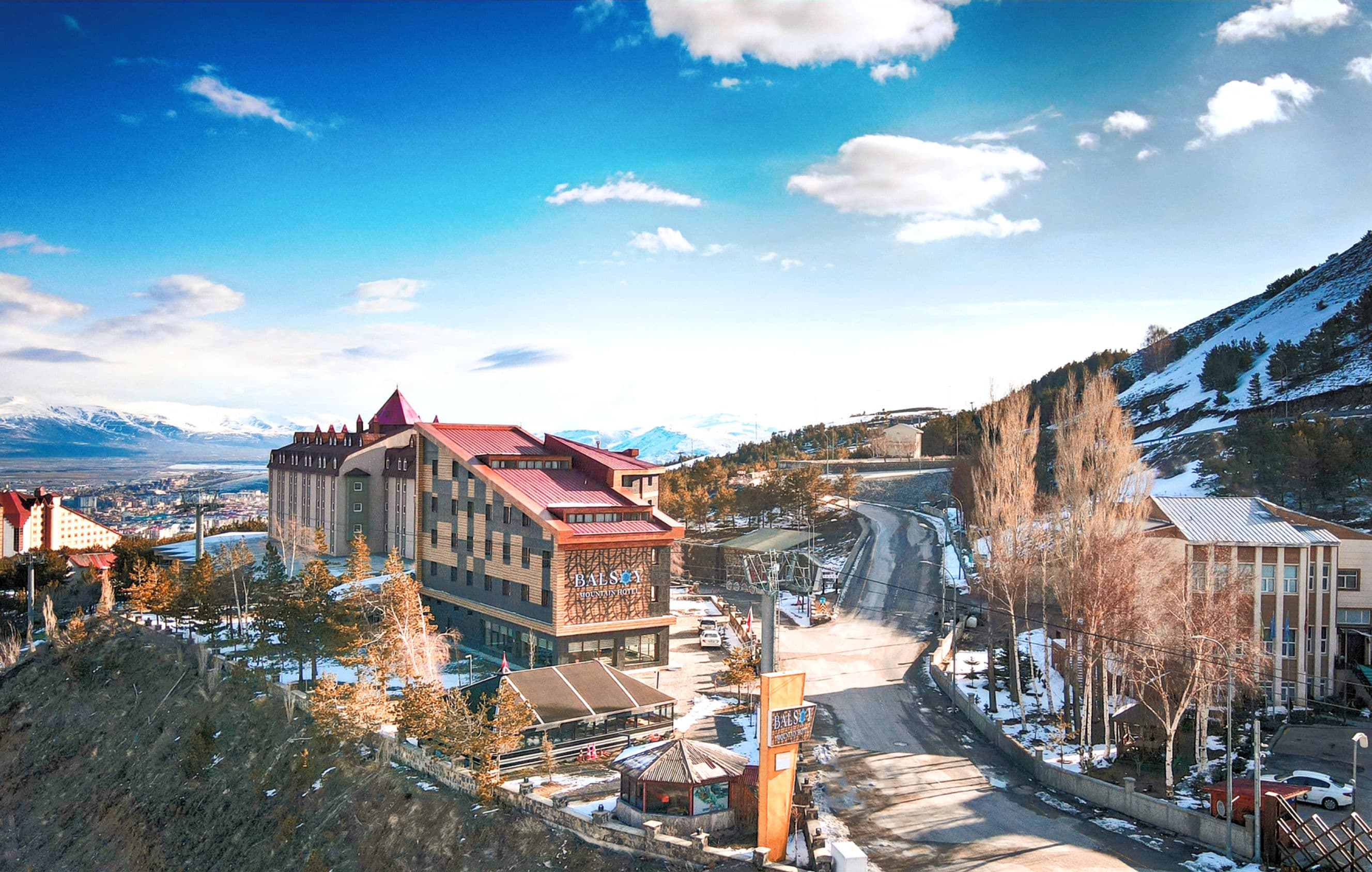 Balsoy Mountain Hotel's red-roofed building beside the snowy slopes in Palandöken