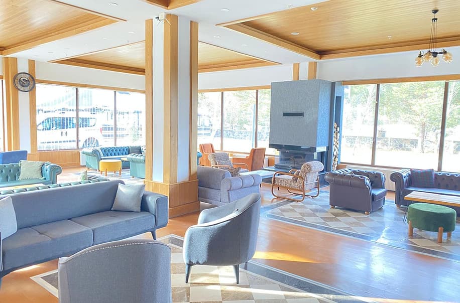 Balsoy Mountain Hotel's lobby with lounge seating, large windows and a fireplace
